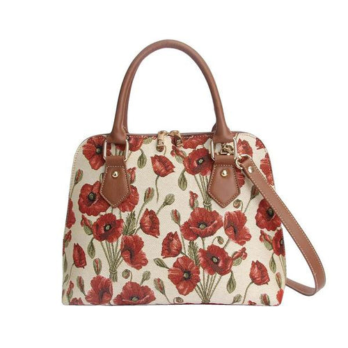 The image shows a handbag embroidered with red poppies with black and green centres and green stems on a beige background. The handbag has brown faux-leather handles and a brown faux-leather strap with brass coloured metal fittings.