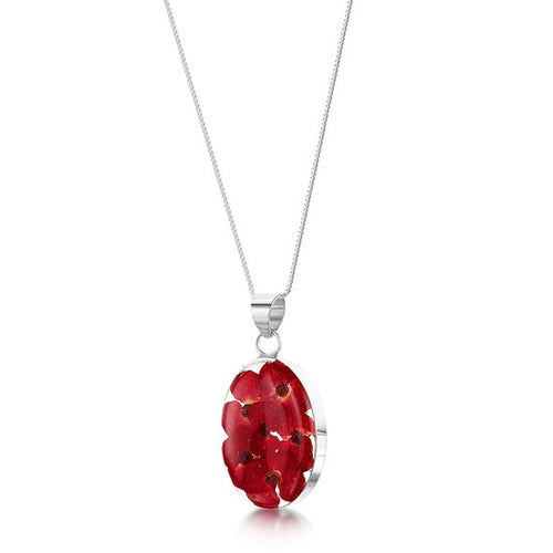 The image shows an oval-shaped sterling silver pendant. The pendant contains real poppy flowers in a clear resin mounted within sterling silver on an 18 inch chain.