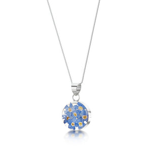 The image shows a round sterling silver pendant. The pendant contains real forget-me-not flowers in a clear resin mounted within sterling silver on an 18 inch chain.