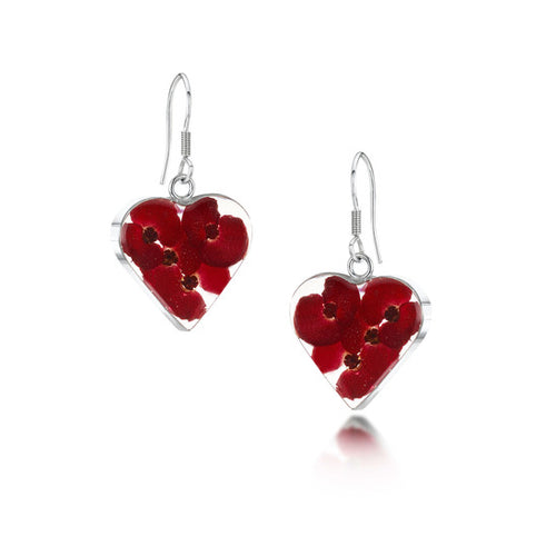 The image shows a pair of sterling silver earrings with drop loop fastenings. The earrings are heart-shaped and contain real poppy flowers contained within resin mounted in sterling silver.